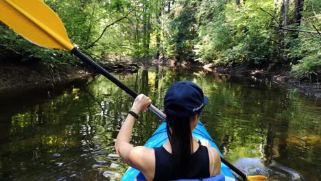 young girl is canoeing in the river