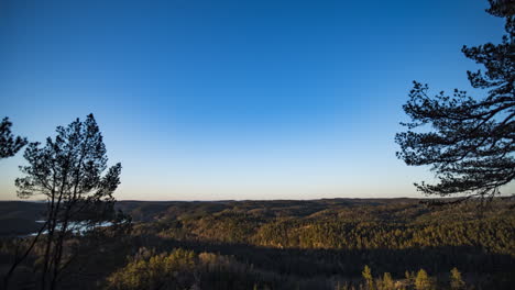 Sunlight-illuminates-forest-in-morning-time-lapse-view-from-hilltop