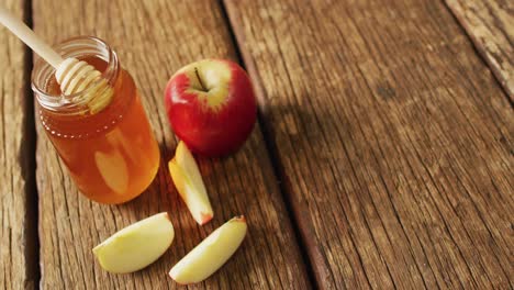 Vídeo-De-Miel-En-Frasco-Y-Manzanas-Y-Rodajas-De-Manzana-Sobre-Una-Superficie-De-Madera