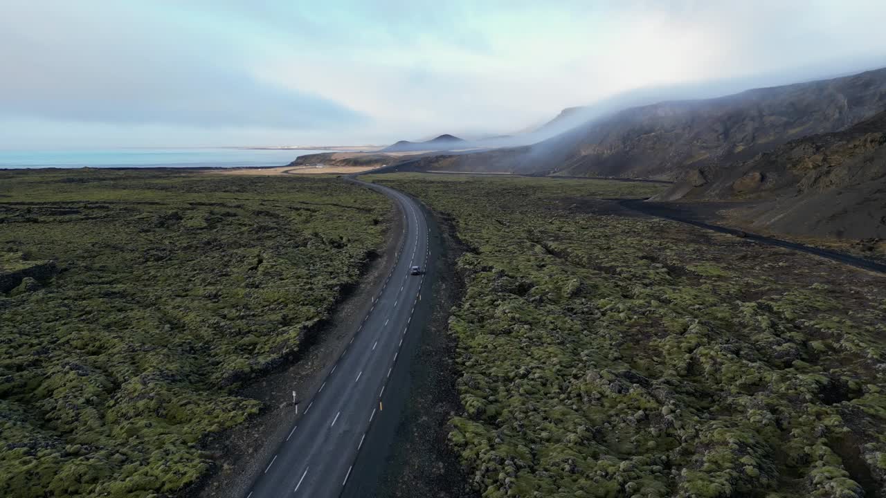 아이슬란드에서 모스 필드에서 겨울에 자동차를 운전하는 드론