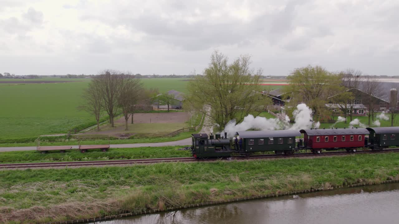 Vista aérea de campos de tulipanes y tren de vapor, Hoorn, campiña de los Países Bajos