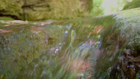 low angle close up of flooding clear water down the stream in switzerland