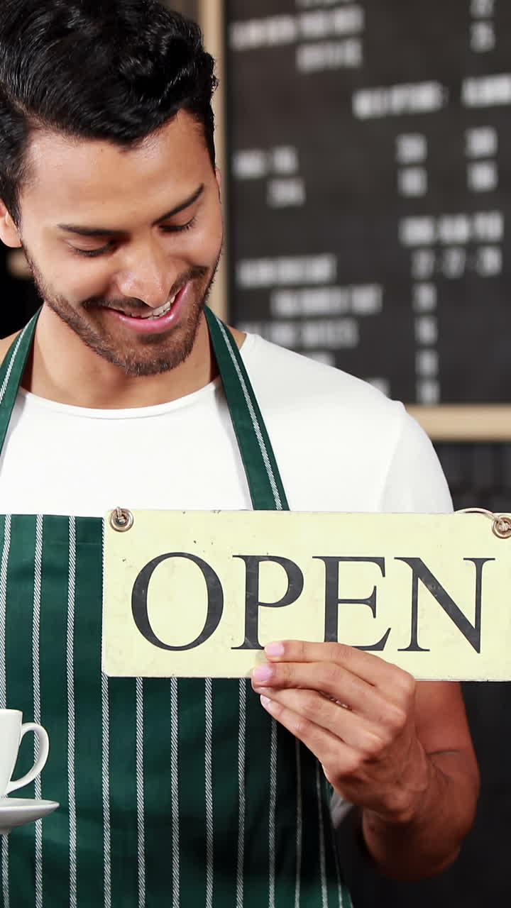 Smiling waiter holding sign and coffees cup