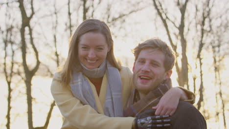 portrait of romantic couple with woman with prosthetic hand hugging in winter or autumn countryside