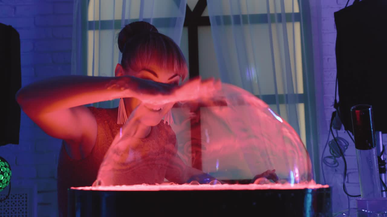 귀여운 소녀는 스탠드에 큰 거품을 부풀려서 그것으로 놀고 쇼를 클로즈업합니다.