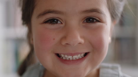 Nahaufnahme-Eines-Porträts-Eines-Schönen-Kleinen-Mädchens,-Das-Mit-Natürlicher-Kindheitsneugier-Lächelt-Und-Ein-Fröhliches-Kind-Mit-Unschuldigem,-Verspieltem-Gesichtsausdruck-Sieht,-4K-Videos