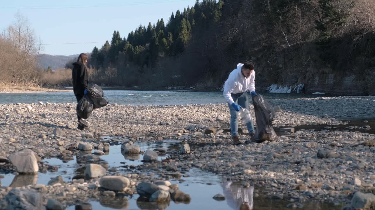 trabajo en equipo limpiando plástico en la playa. voluntarios recogen basura en una bolsa de basura. contaminación plástica y concepto de problema ambiental. limpieza voluntaria de la naturaleza del plástico. ecologización del planeta