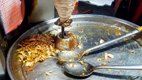 drizzling the chicken with spices for shawarma