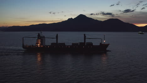 logistics freight ship motors out at night heading towards south china sea