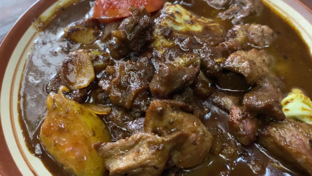 Tongseng, comida deliciosa servida em um prato. Ensopado de carne de cabra cozido com molho de soja doce, leite de coco, repolho fatiado e tomates. Comumente encontrado em Java Central, de Surakarta a Yogyakarta.