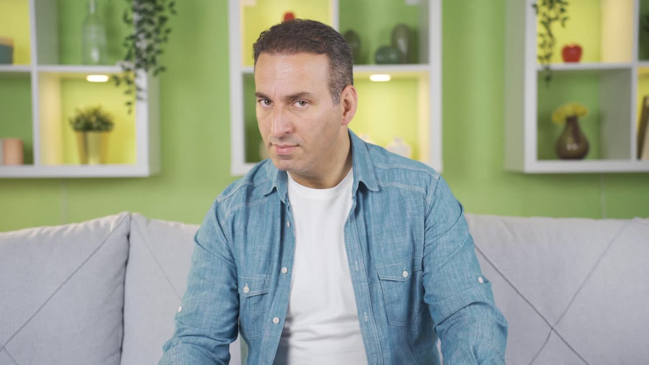 집에서 분노로 카메라를 바라보는 분노하고 반항적인 남자