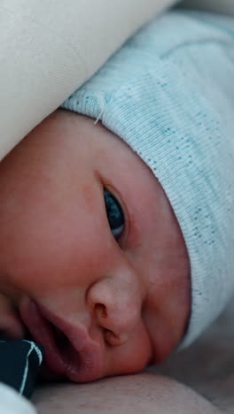 newborn child looks confused right after being born. baby lies on the chest of his bearded dad. close up. vertical video