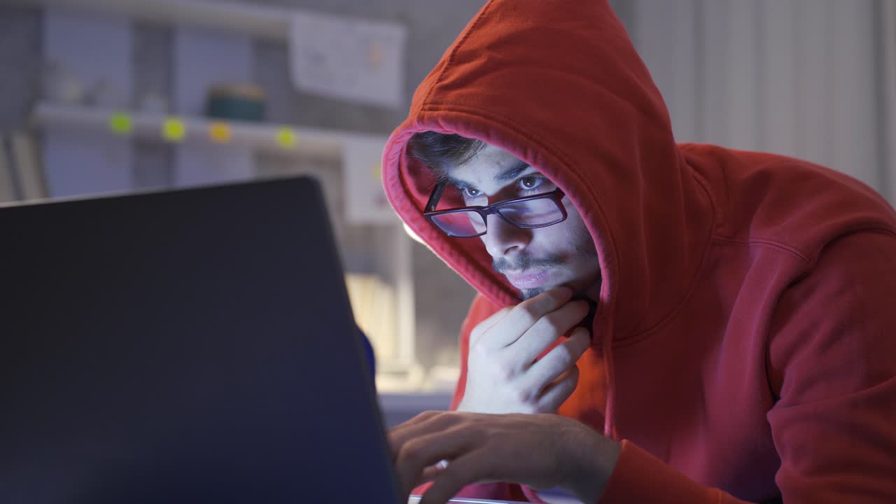 un joven mirando software en la cama por la noche.