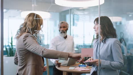 business people using sticky notes brainstorming team leader woman working with colleagues writing on glass whiteboard showing problem solving strategy in office meeting