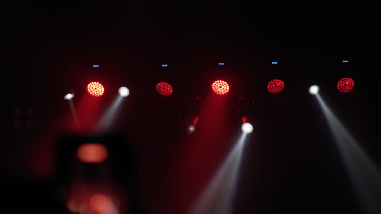 Concert stage lights row with white beam and red par glow
