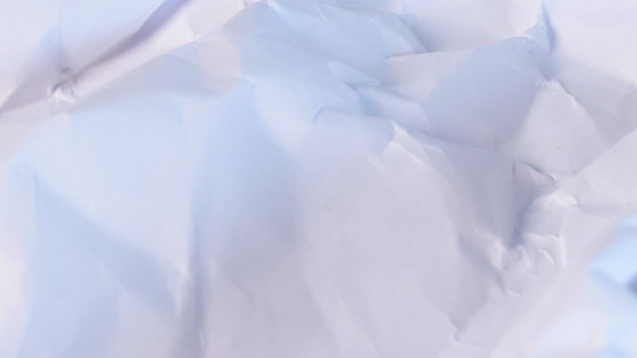 Wrinkled white paper sheet, blank paper macro shot close up view with rotating motion.