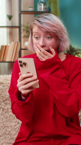 young woman celebrating victory in online mobile game expressing excited surprise joyful emotions