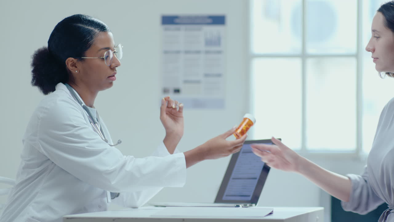 mujer médico dando pastillas al paciente en consulta en la clínica
