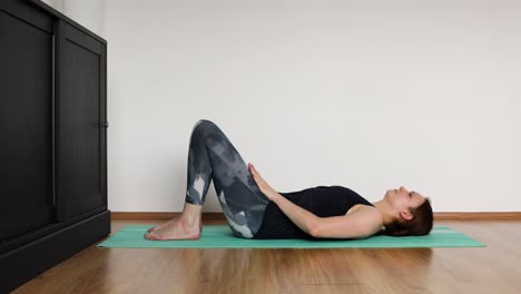 young girl doing her workout at home in the living room - crunch exercise
