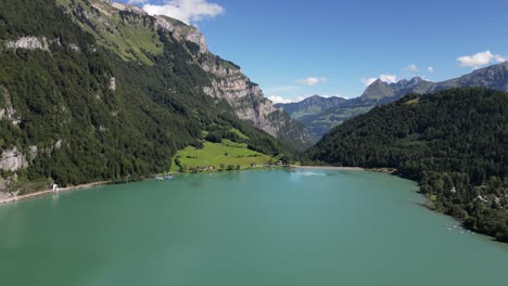 Majestic-Peaks,-Crystal-Waters:-Aerial-view-of-green-forest-and-Lakeside-Mountains