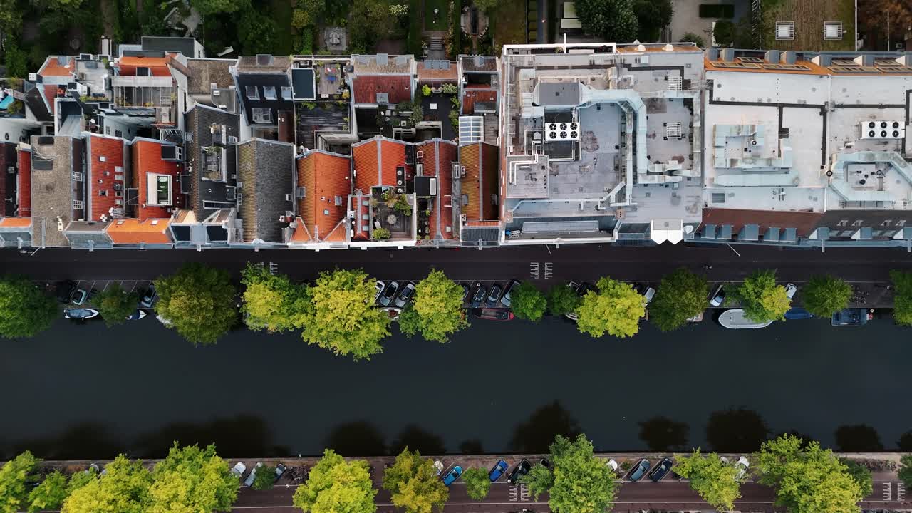 Birdseye flight over rows of Amsterdam houses and intersecting canals