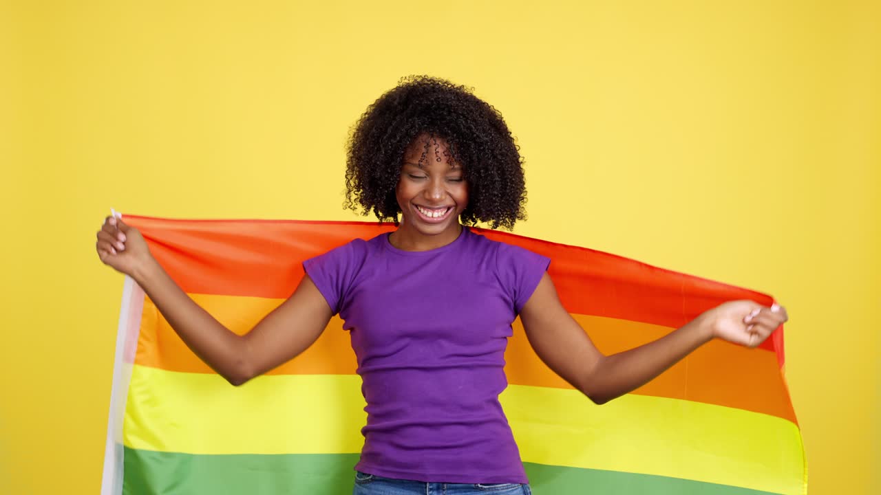 Happy African American Woman Wrapped in a Rainbow Pride Flag