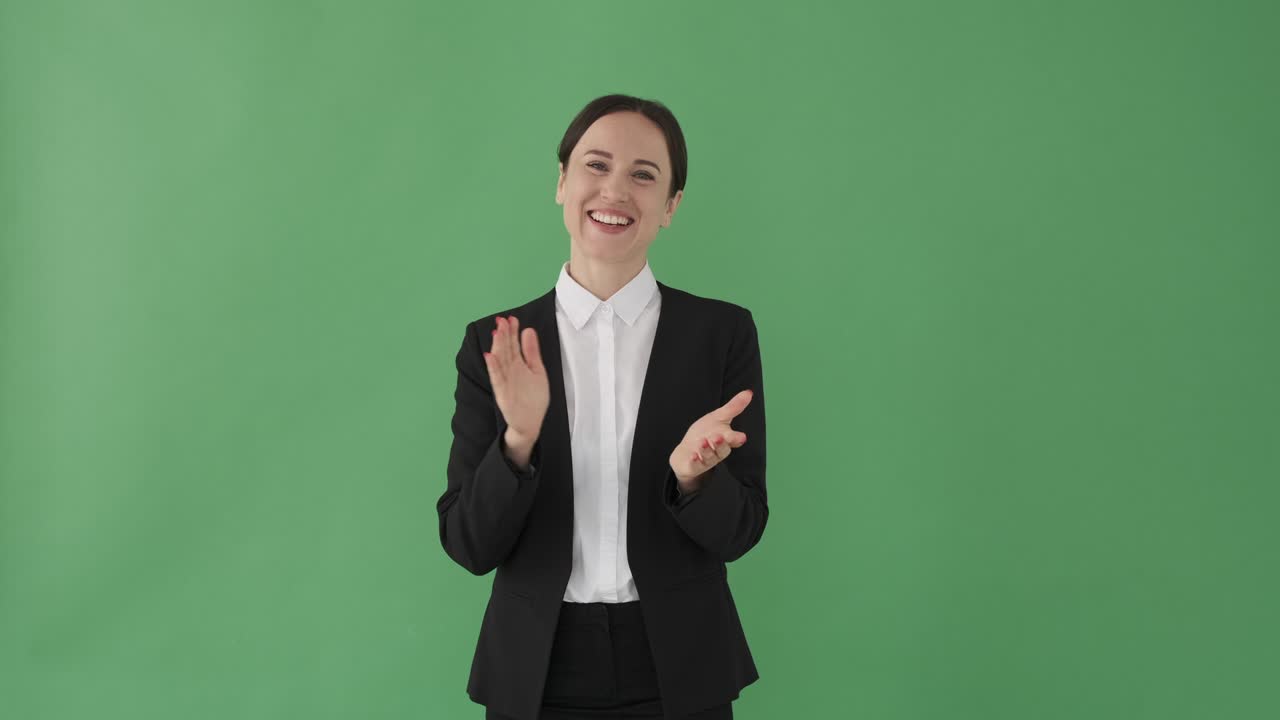 una mujer de negocios aplaudiendo sobre un fondo verde.