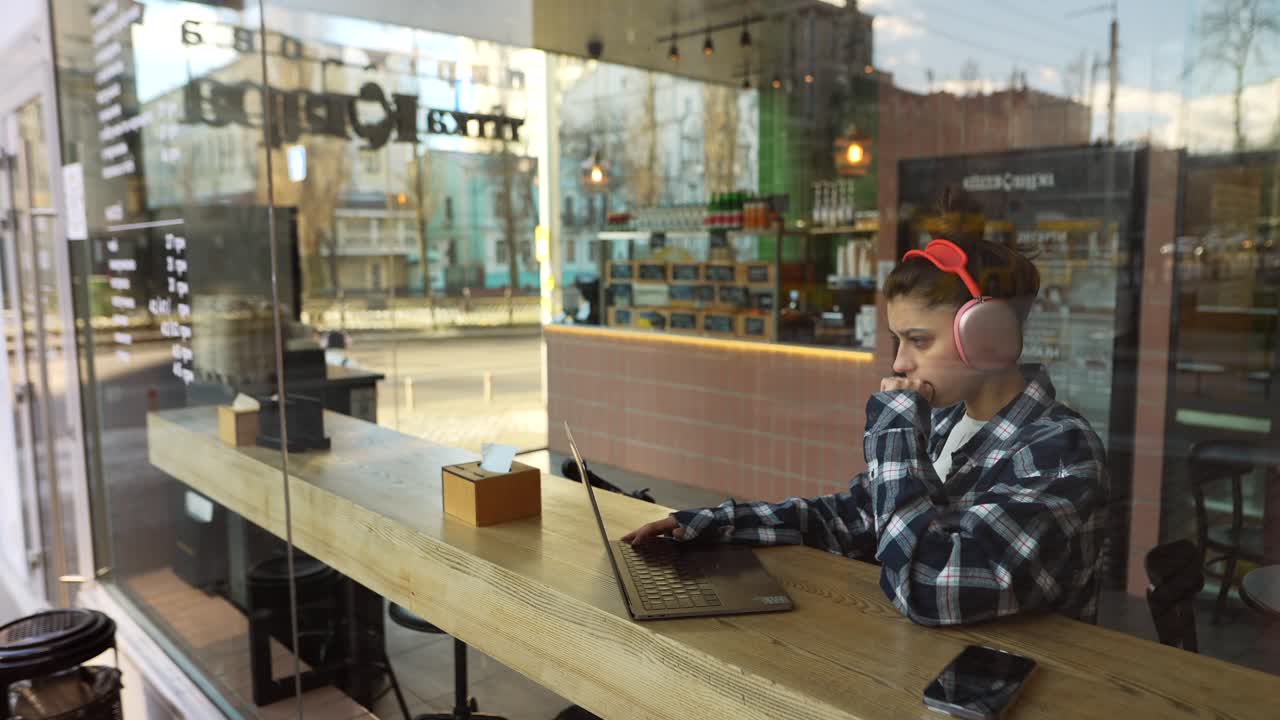 mujer trabajando en una computadora portátil en un café