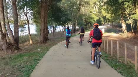 1-man-and-2-women-Cycling-on-a-sunny-day-near-the-river