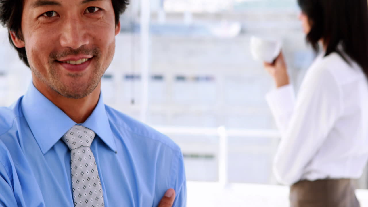 스마트 시계를 착용 한 사업가 가 카메라 에 미소 짓고 있다