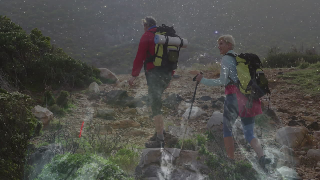 Couple hiking mountainous trail for travel ad, overlaying animated elevation chart and route icons