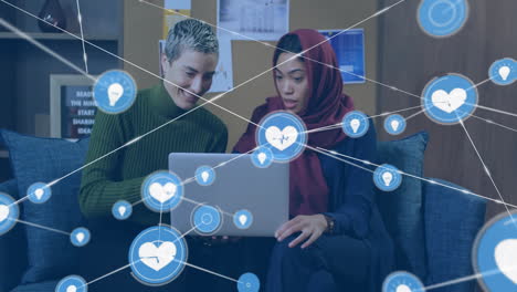 network of social media likes and connections animation over two women using laptop