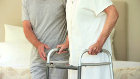 male nurse helping woman to walk with a zimmer frame