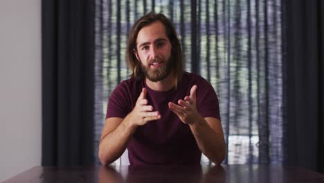 portrait of caucasian man talking on videocall while sitting at home