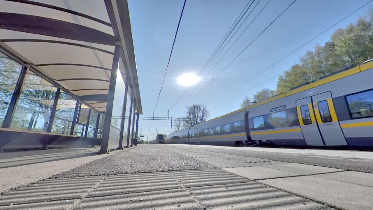 Low Wide Angle of Swedish train passing by train stop on sunny morning, Gothenburg