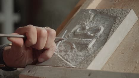 stone engraving close-up moment with working man in hand and his shape tool, italy.