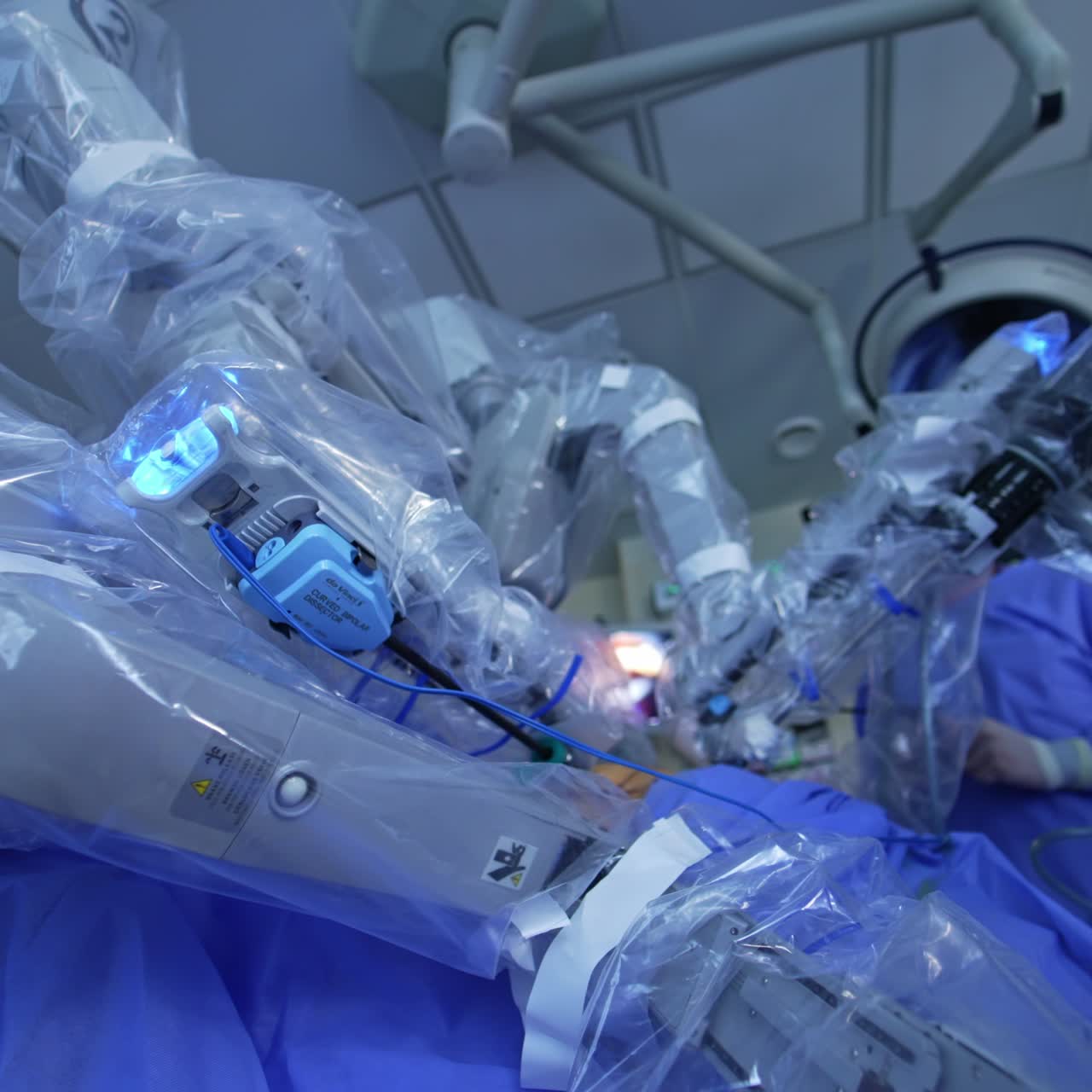 Futuristic robotic equipment conducting surgery in modern clinics. Medical staff controlling the operational process. Low angle view