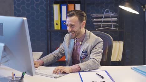 Stylish-and-charismatic-businessman-using-computer-in-office-rejoicing,-getting-good-news,-winning.