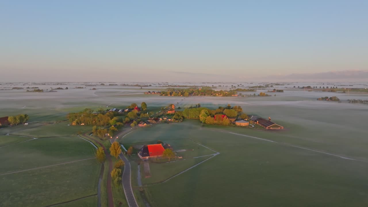 Luchtfoto van de kerk van Swichum en huizen in de ochtendmist, Nederland