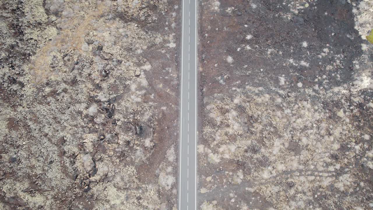 toma aérea de camino recto en montañas rocosas