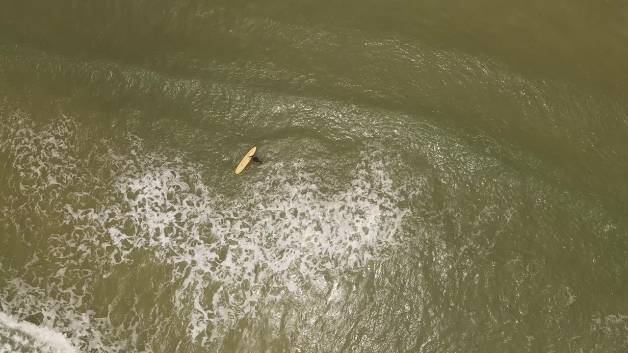 우루과이의 라 페드레라 해변, 바닷물에 들어가는 고립되고 알아볼 수 없는 서퍼 남자