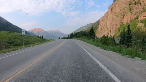 POV-while-driving-on-Million-Dollar-Highway-in-Uncompahgre-River-Valley-with-dramatic-views-of-San-Juan-Mountains-near-Ouray-Colorado