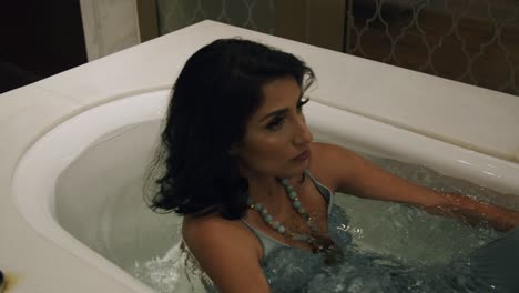 Woman-In-Elegant-Clothes-Falls-Back-Into-Tub-Filled-With-Water---Static,-Medium-Shot