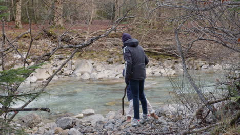 family hiking by a river in the woods