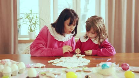 mother and daughter decorating easter cookies