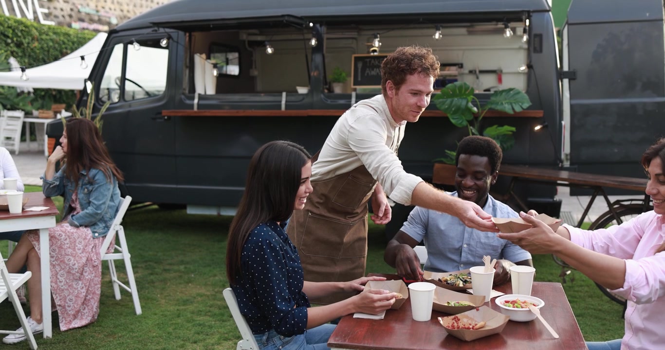 Diverse Friends Enjoying Street Food from a Food Truck Outdoors