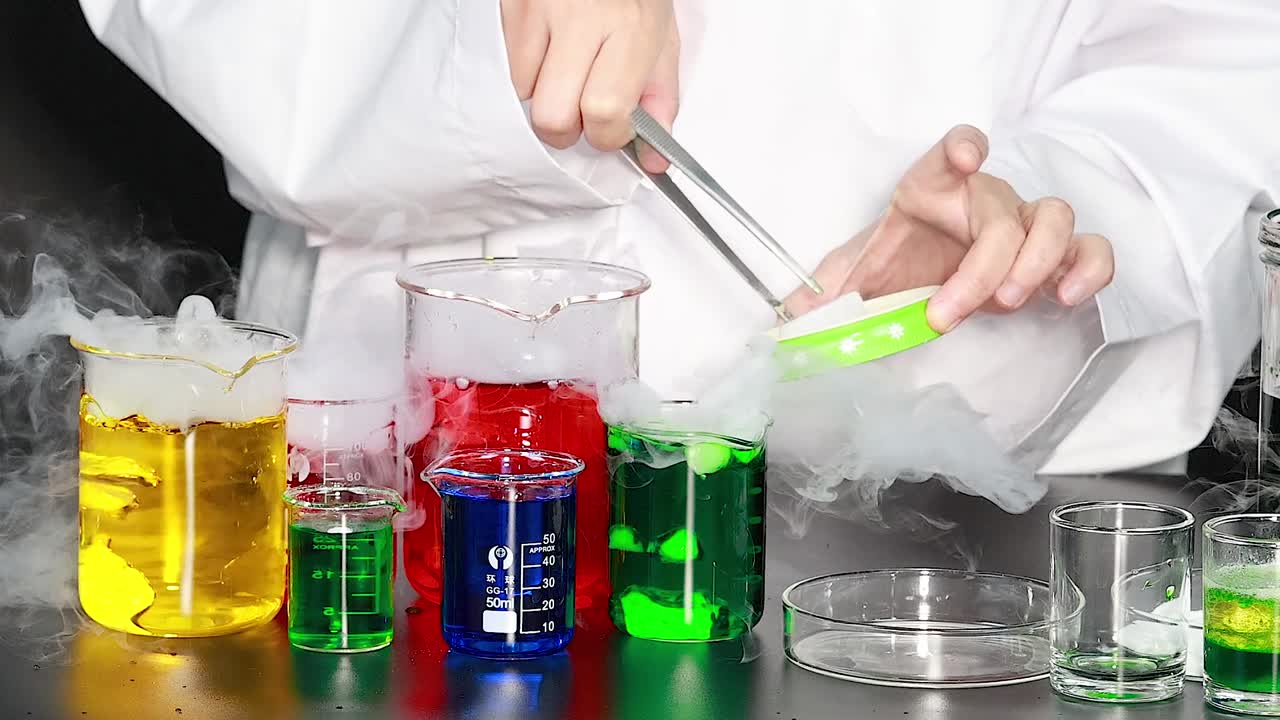 Close-up of colorful liquids reacting in beakers with visible smoke and laboratory tools.