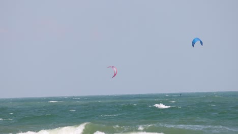 los kitesurfistas se deslizan sobre las ondas del océano