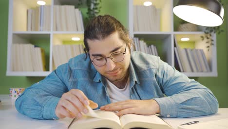 un primer plano de un joven leyendo un libro.