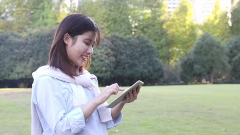 4k: beautiful asian woman listening music under sun flare at park,shanghai,china